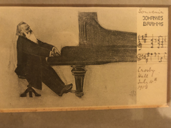 Postcard of Brahms playing piano. Postcard of Brahms playing piano.