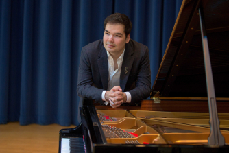 Alim Beisembayev sitting at a piano Alim Beisembayev sitting at a piano