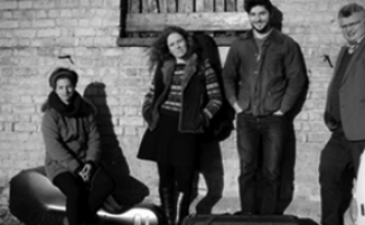 Black and white photograph of the members of the Allegri Quartet in front of a brick building Black and white photograph of the members of the Allegri Quartet in front of a brick building