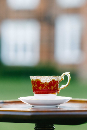 A coffee cup in front of stately home