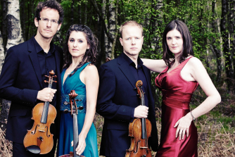 Carducci Quartet stand holding violin and cello Carducci Quartet stand holding violin and cello