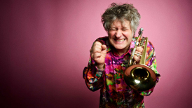 Eric Vloeimans playing trumpet against a pink background